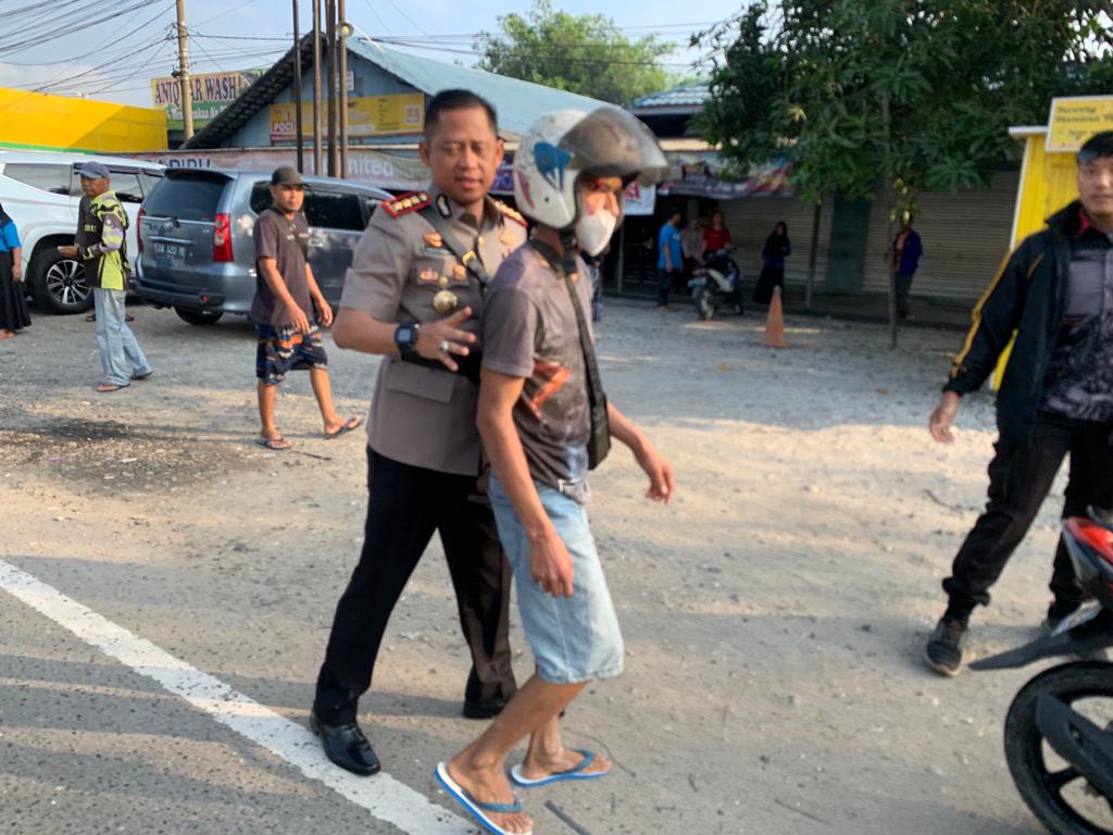 TOLONG LAKA – Kapolresta Banjarmasin Kombes Pol Sabana AM saat menolong warga yang mengalami laka ringan
