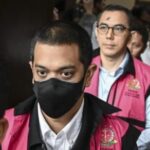 Terdakwa Beneficial owner PT Navigator Khatulistiwa Muhamad Kerry Adrianto Riza (tengah) berjalan meninggalkan ruang sidang usai mengikuti sidang dakwaan di Pengadilan Tipikor, Jakarta Pusat, Senin (13/10/2025)